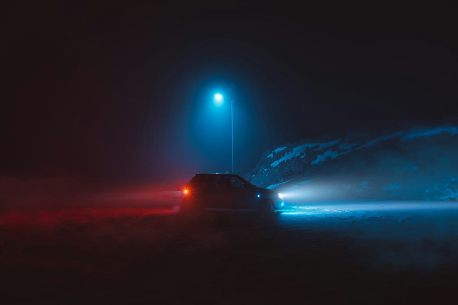 Un’auto nella nebbia illuminata di blu